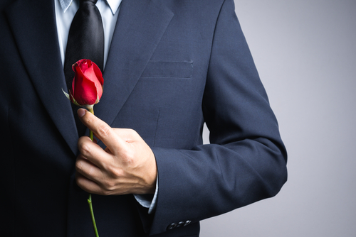 Man in suit and tie with a red rose