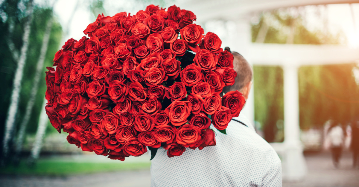 Man carrying giant bouquet of roses