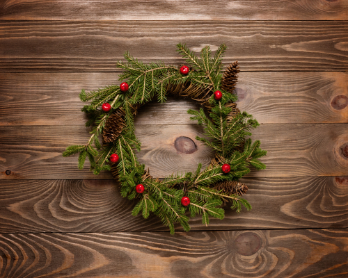 Pine and berry wreath on wooden background