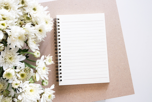 white flowers with open lined notebook