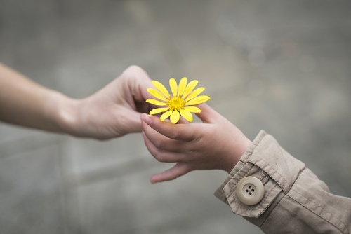 Girl handing child flower