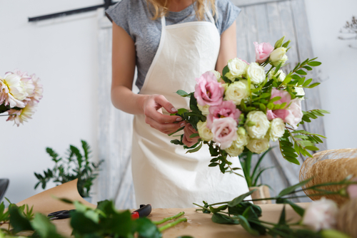 Florist preparing fresh white and pink flowers