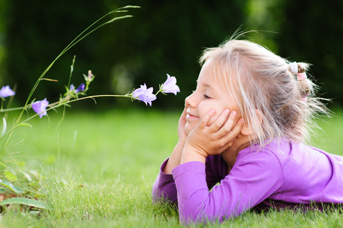 Small girl smelling flower