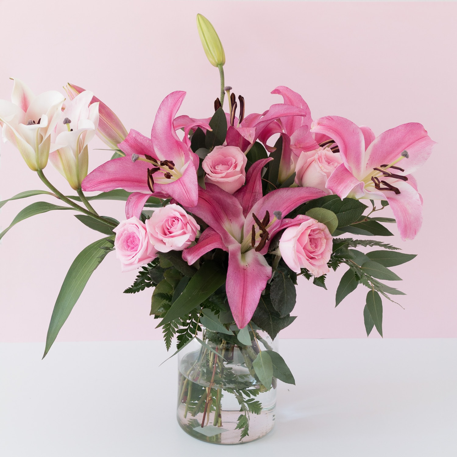 Bouquet of big pink lilies in a vase with roses