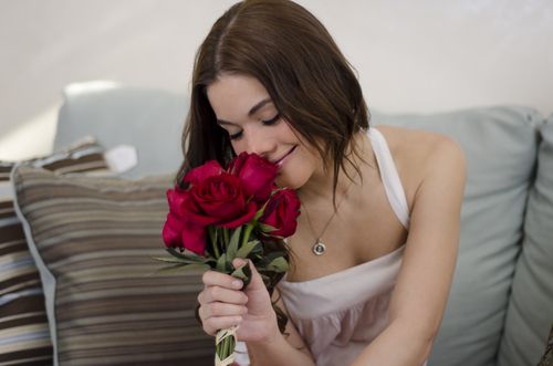 Happy girl smelling rose bouquet