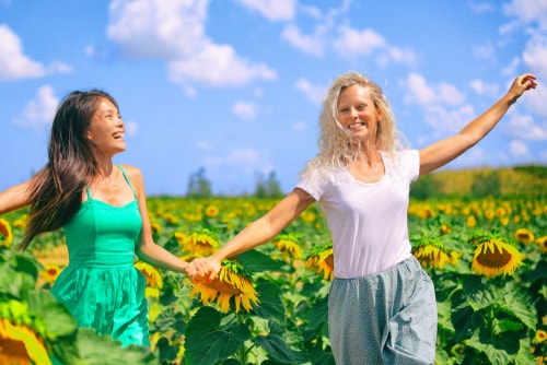 Friends dancing in sunflower field