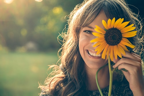 girl with sunflower over eye