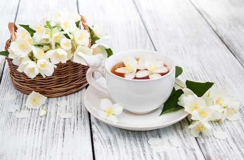 Weiße Jasminblüten und Tee
