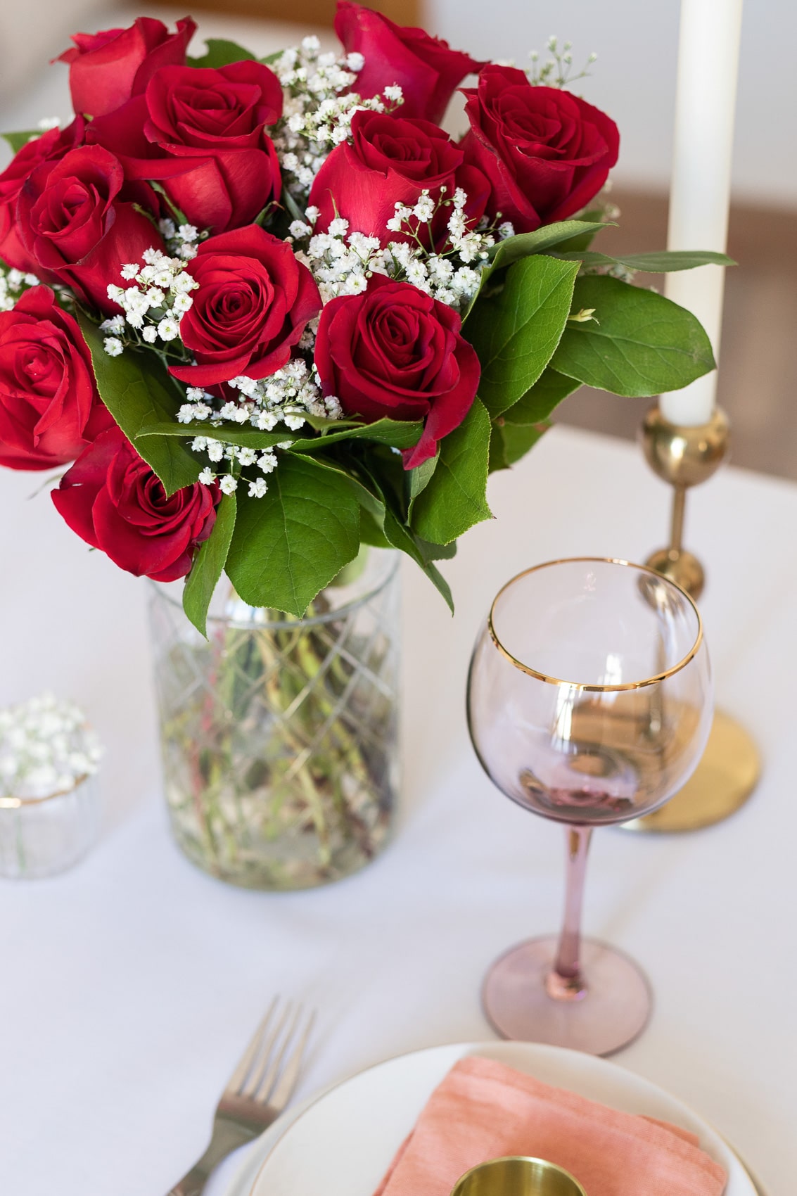 Red roses on a table with wine glass