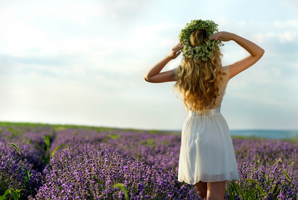 jeune femme dans un champ de lavande avec couronne de fleurs