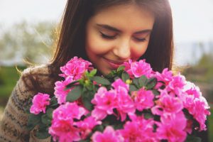femme avec bouquet de fleurs roses