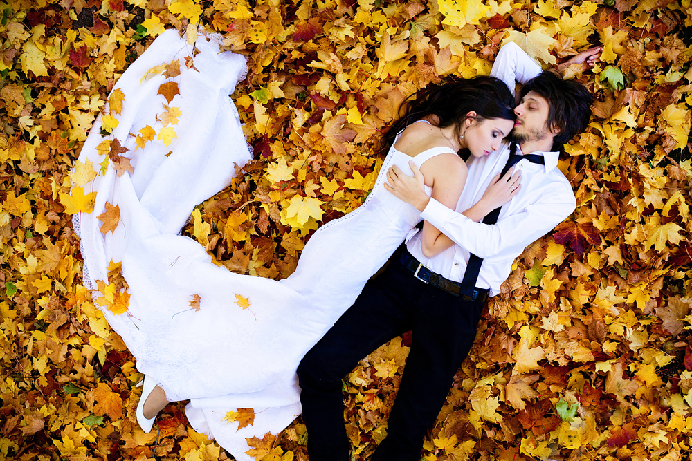 couple allongé sur des feuilles mortes