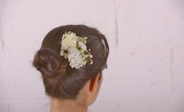 femme de dos avec barrette de fleurs fraîches dans les cheveux