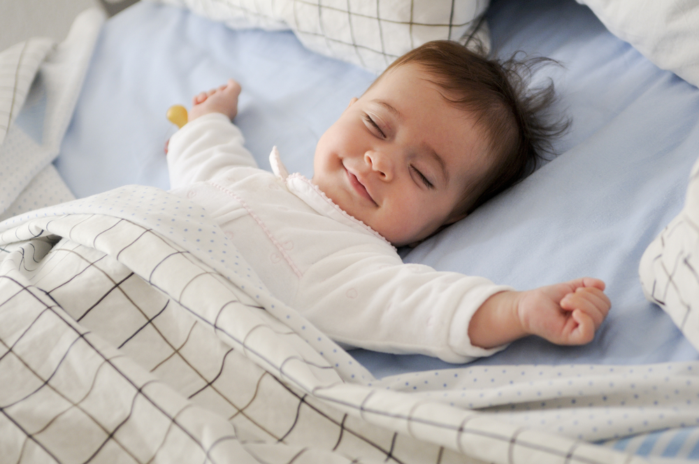 bébé souriant dans un lit