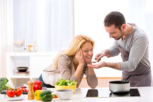 homme faisant gouter un plat à une femme