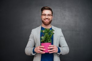 homme souriant avec une plante