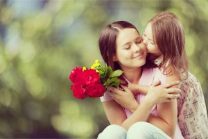 petite fille offrant des fleurs à sa maman