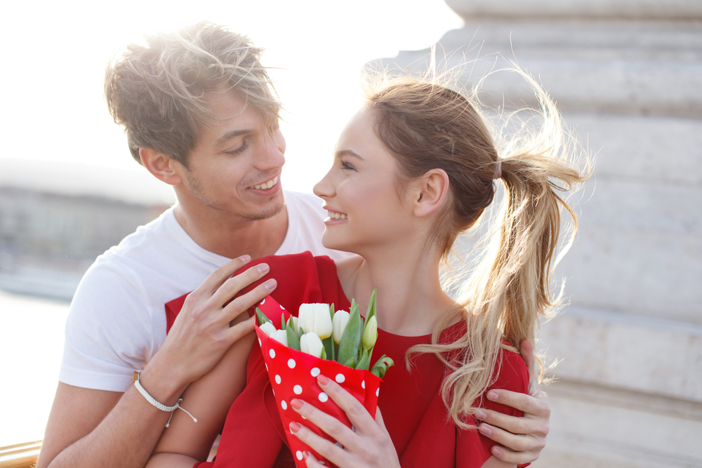 couple avec bouquet de fleurs se regardant