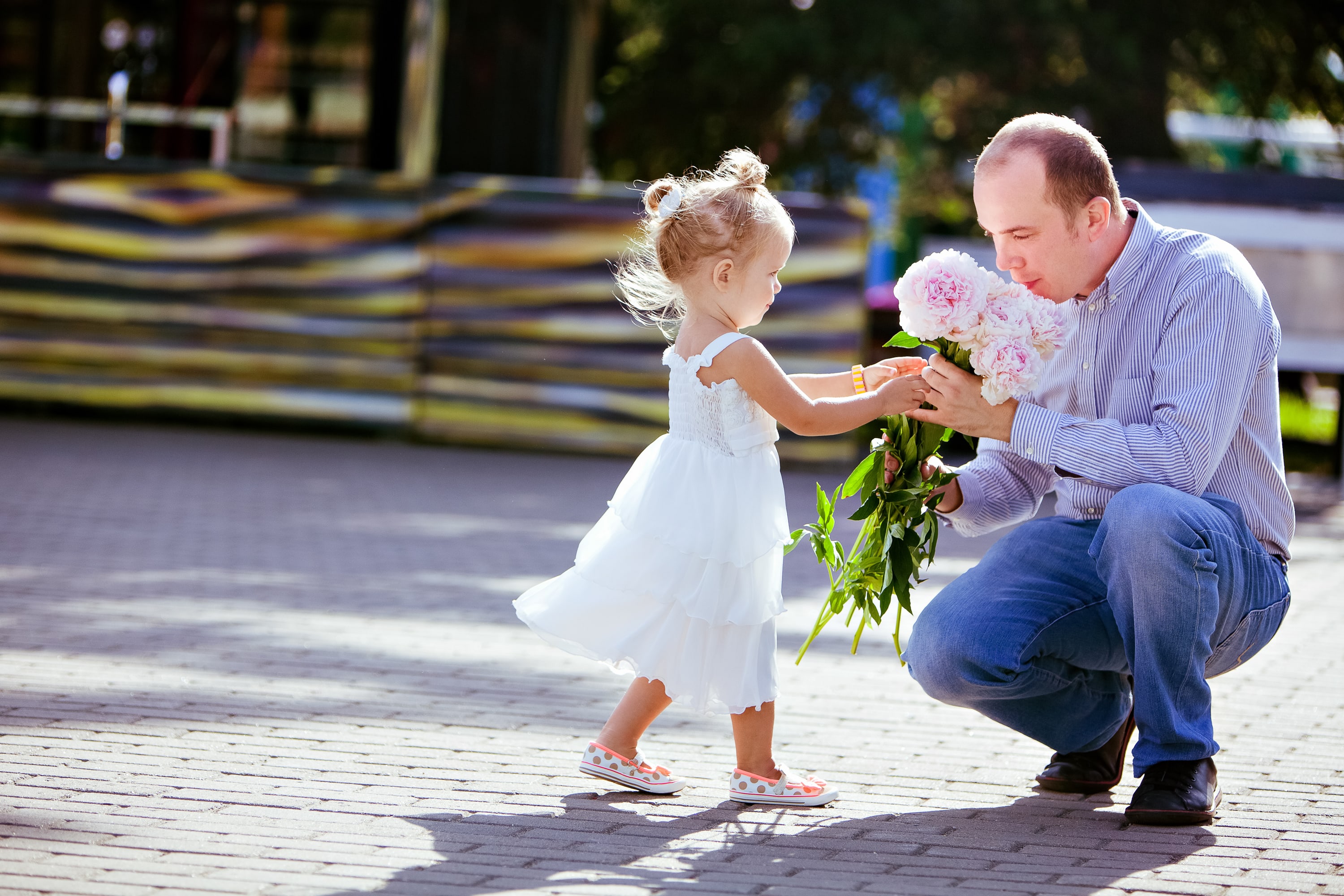 petite fille offrant des fleurs à son pere
